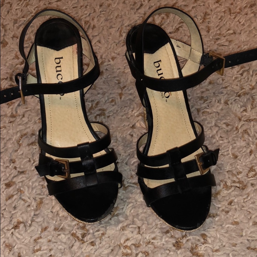 Black/gold heel wedges. Buckle in front.